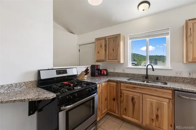 a kitchen with stainless steel appliances granite countertop a refrigerator and a stove