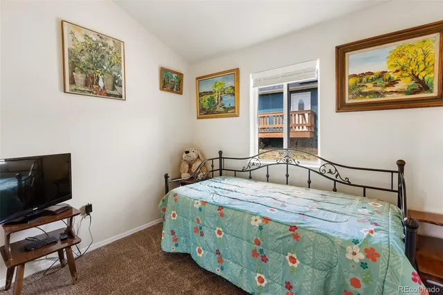 a bedroom with a bed and painting on the wall