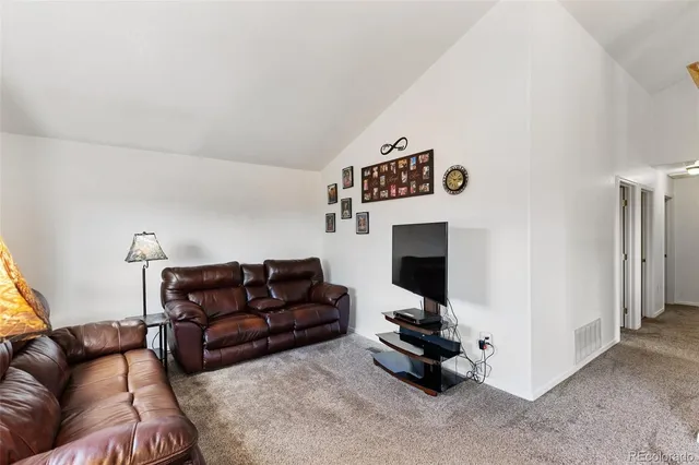 a living room with furniture and a floor to ceiling window