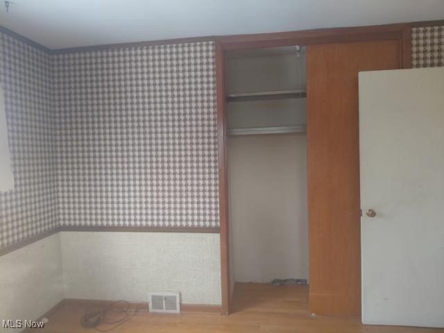 14849 Whitney Road Strongsville, OH 44136 - Photo 9 of 16 Unfurnished bedroom with wallpapered walls, a closet, and light wood-type flooring
