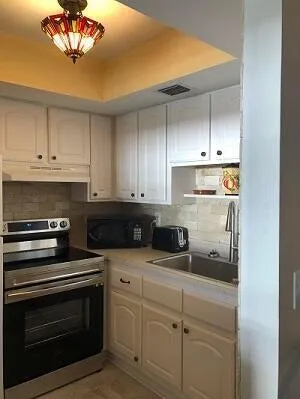 a kitchen with appliances a sink and cabinets