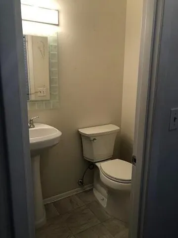 a white toilet sitting next to a bathroom sink