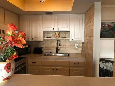 a kitchen with kitchen island granite countertop white cabinets and stainless steel appliances