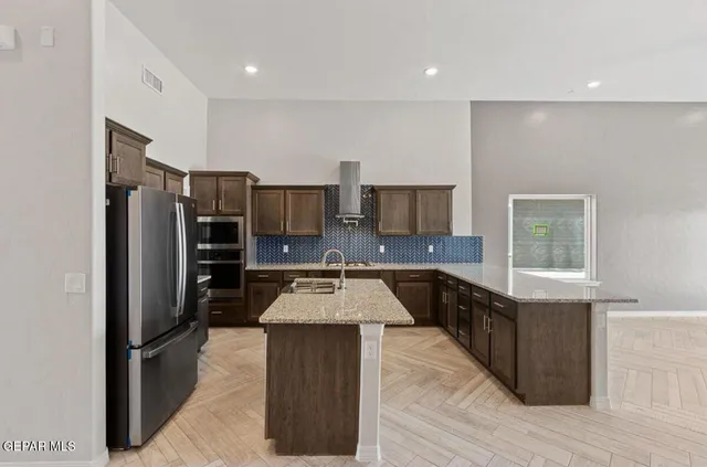 a kitchen with stainless steel appliances granite countertop a refrigerator and a stove