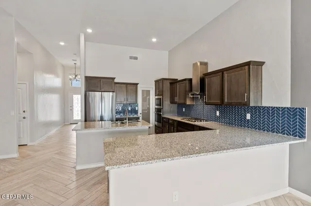 a large kitchen with kitchen island granite countertop a sink and stainless steel appliances