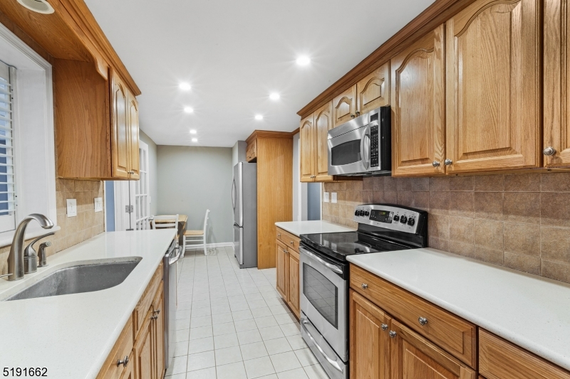 27 Hillcrest Road Warren, NJ 07059 - Photo 4 of 25 a kitchen with stainless steel appliances granite countertop a sink a stove and a refrigerator