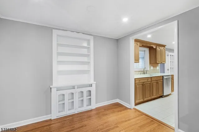 a view of an empty room with a kitchen and a sink