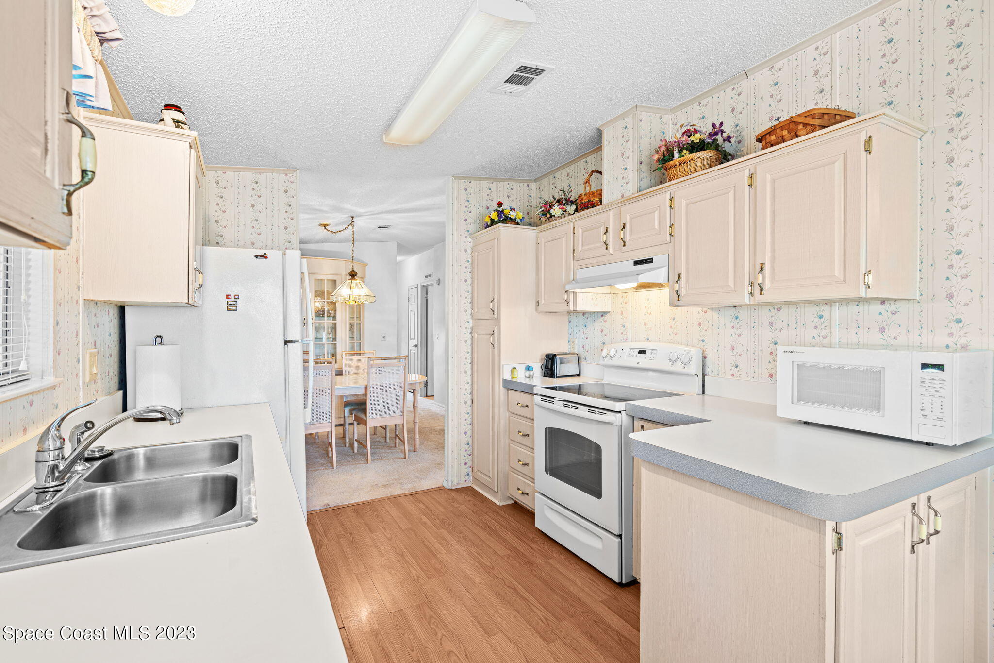 701 Gladiolus Drive Barefoot Bay, FL 32976 - Photo 6 of 19 a kitchen with granite countertop a sink stove and refrigerator