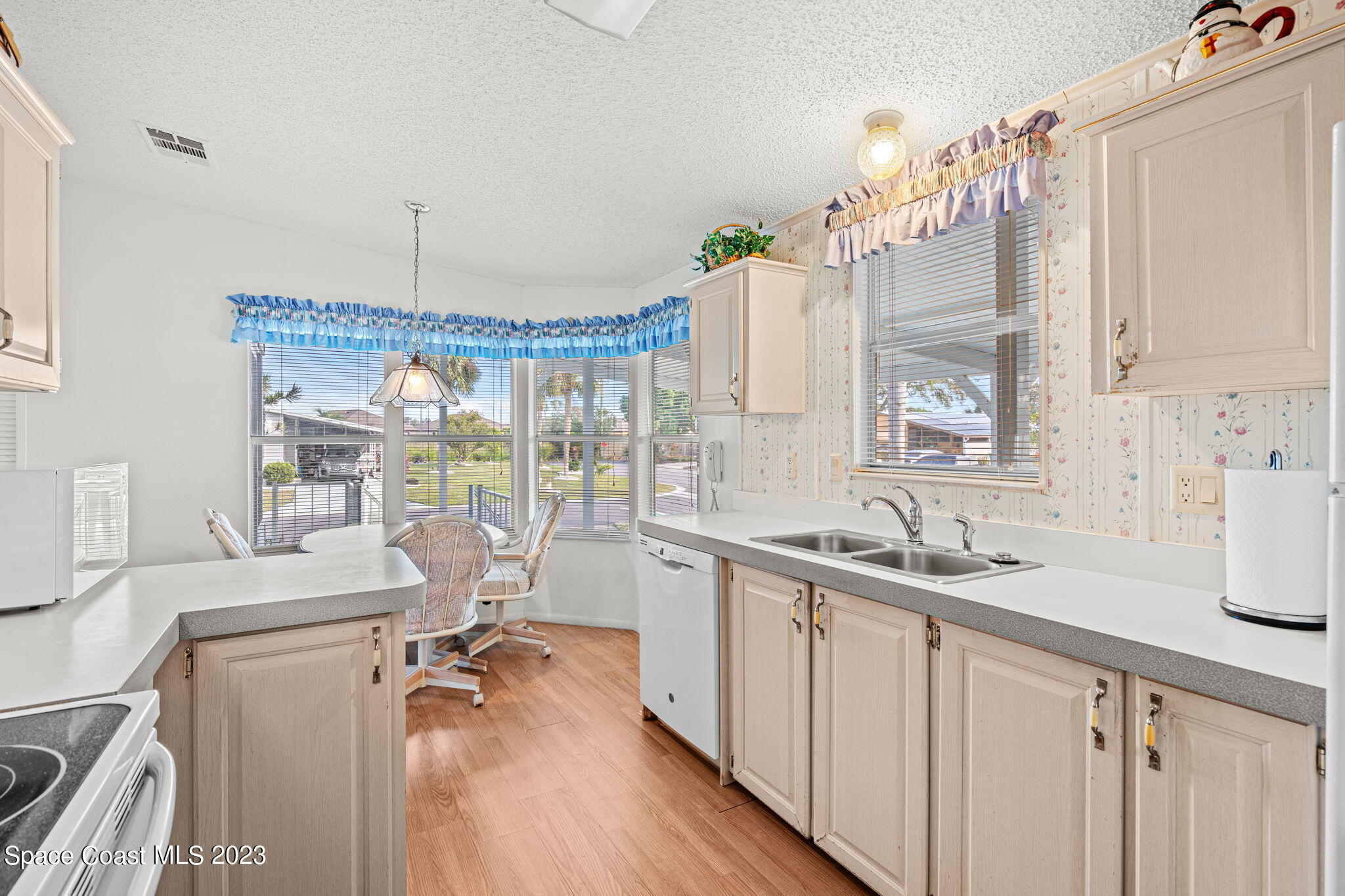 701 Gladiolus Drive Barefoot Bay, FL 32976 - Photo 7 of 19 a kitchen with a sink a counter top space and living room view