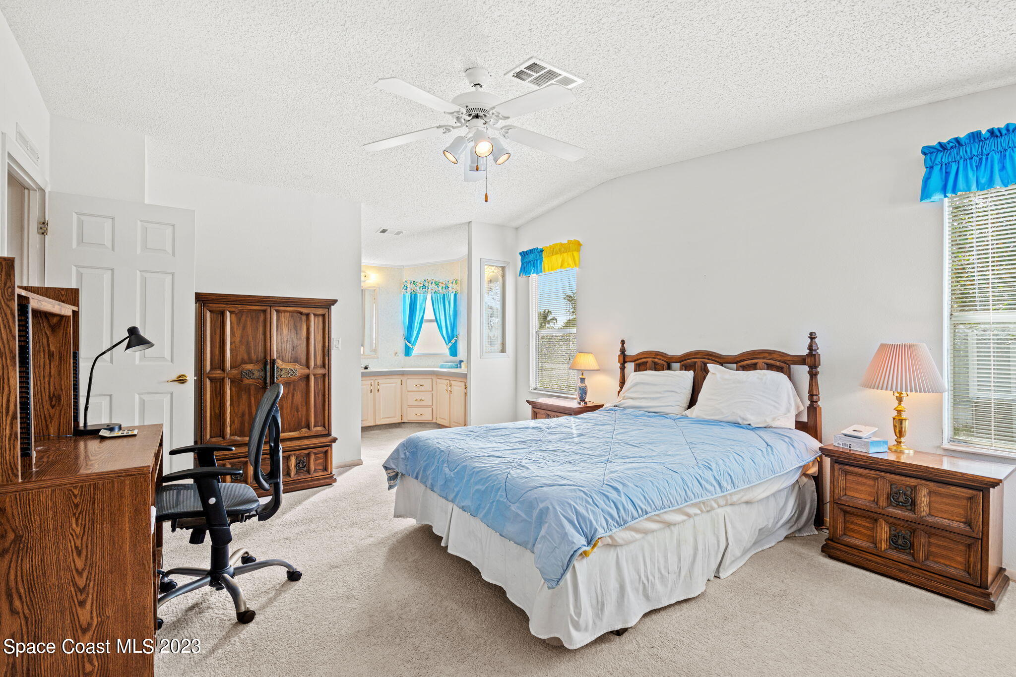 701 Gladiolus Drive Barefoot Bay, FL 32976 - Photo 9 of 19 a bedroom with a bed a table and a chandelier