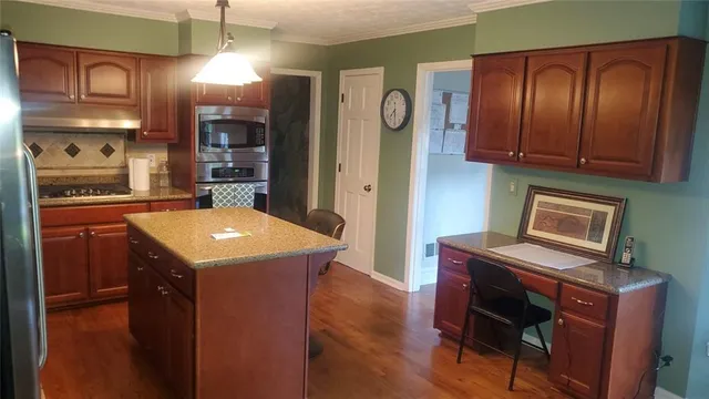 a kitchen with a refrigerator a stove and wooden cabinets