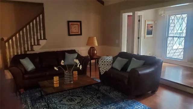 a living room with furniture and wooden floor