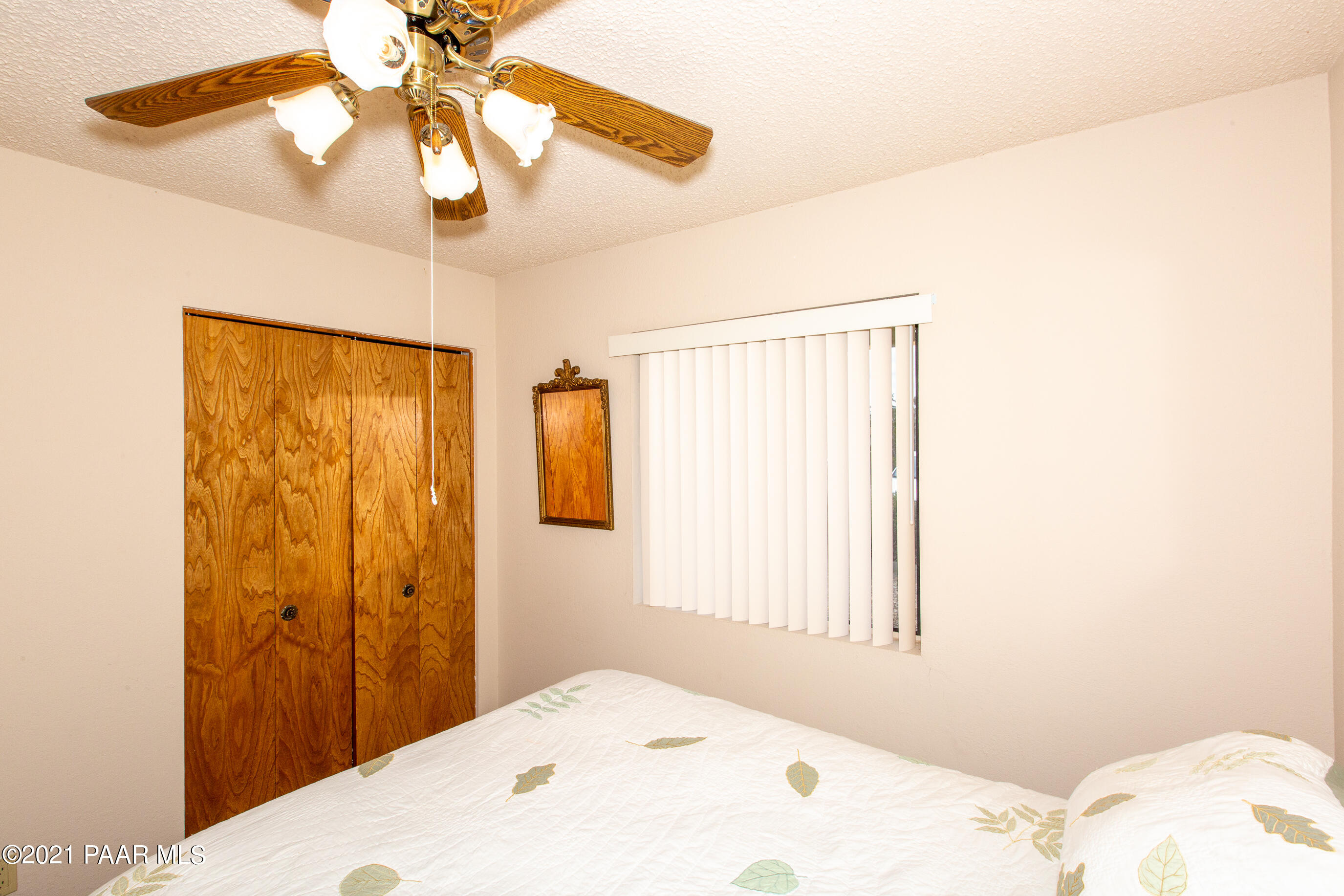 11991 Rawhide Ridge Dewey, AZ 86327 - Photo 17 of 29 a bedroom with a bed and a chandelier
