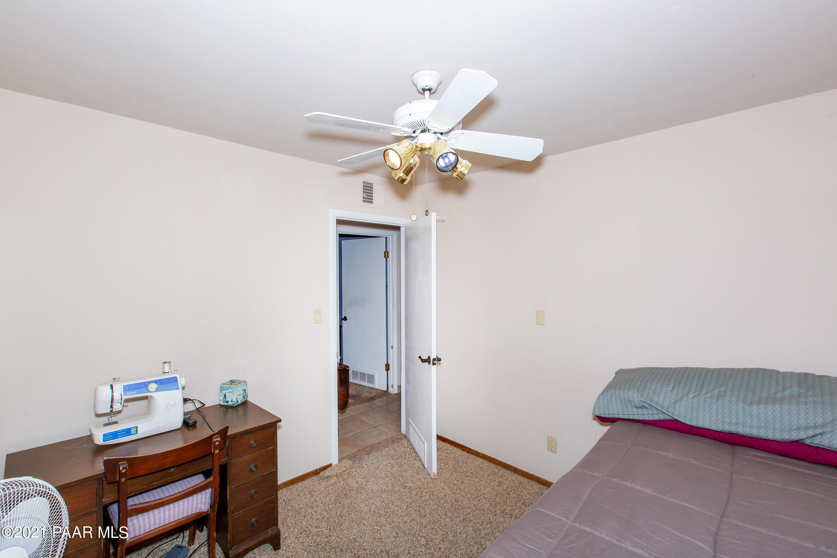 11991 Rawhide Ridge Dewey, AZ 86327 - Photo 24 of 29 a bedroom with a bed and a chandelier