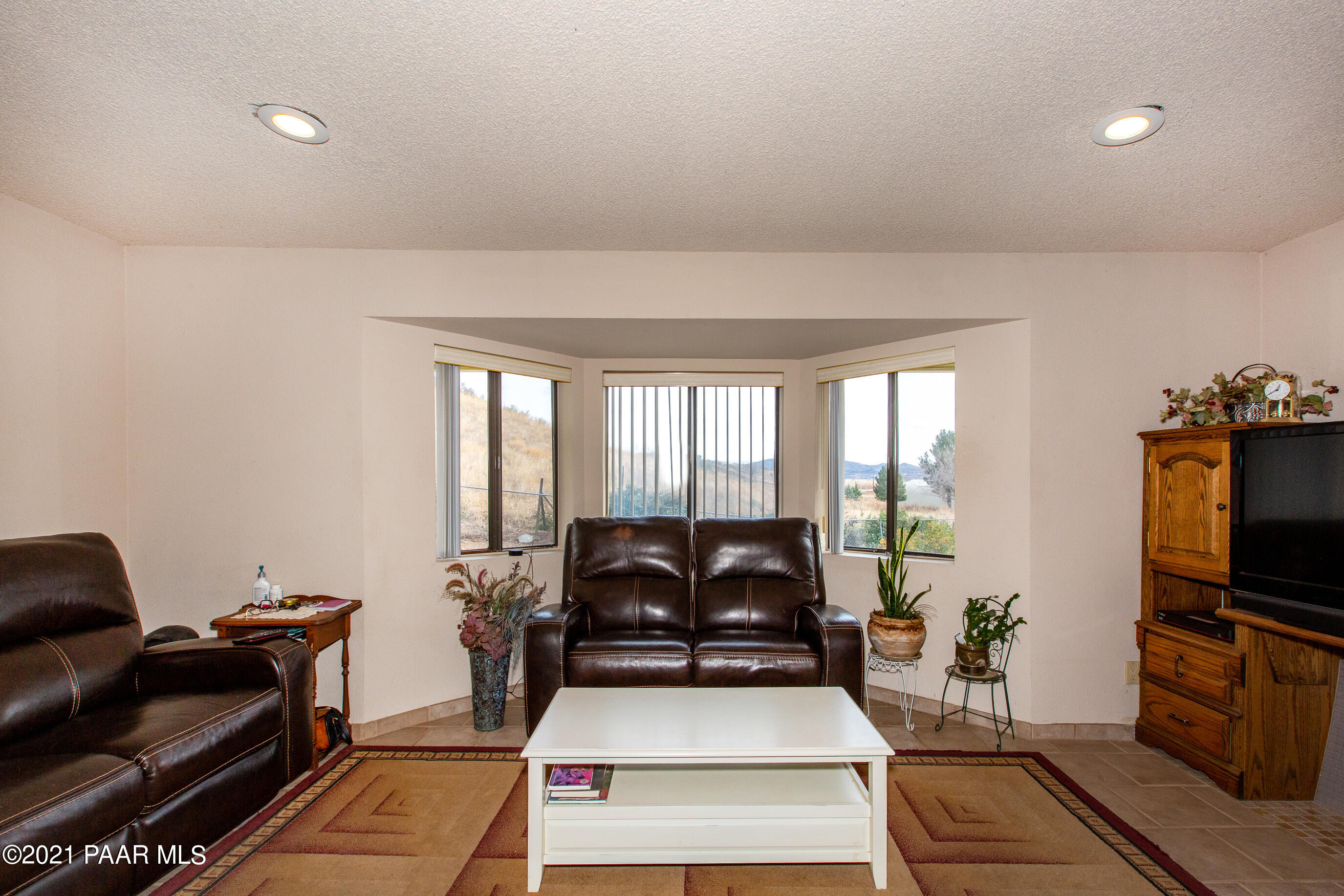 11991 Rawhide Ridge Dewey, AZ 86327 - Photo 3 of 29 a living room with furniture a flat screen tv and a floor to ceiling window