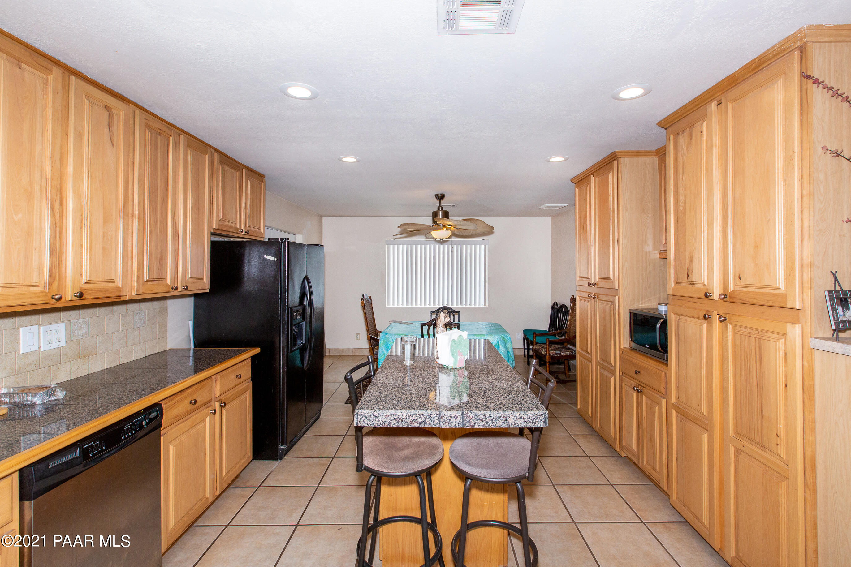 11991 Rawhide Ridge Dewey, AZ 86327 - Photo 6 of 29 a kitchen with stainless steel appliances granite countertop a refrigerator a sink dishwasher and wooden cabinets with a large window