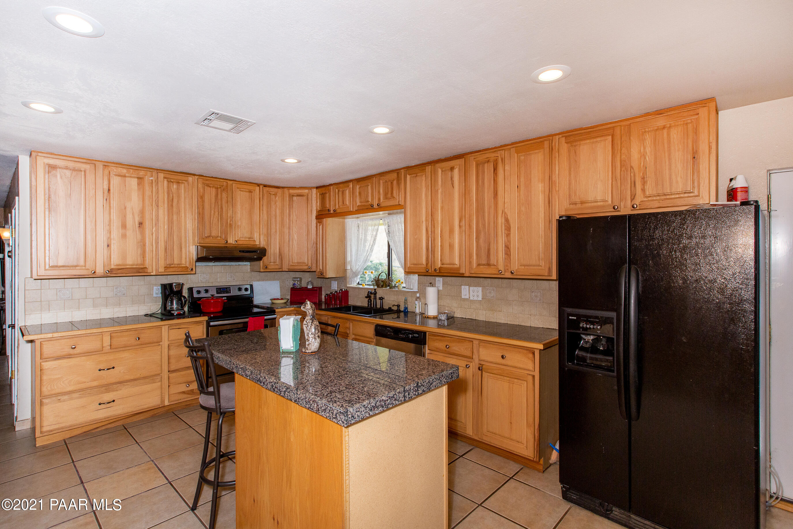 11991 Rawhide Ridge Dewey, AZ 86327 - Photo 9 of 29 a kitchen with a refrigerator a sink dishwasher and a stove top oven with wooden floor