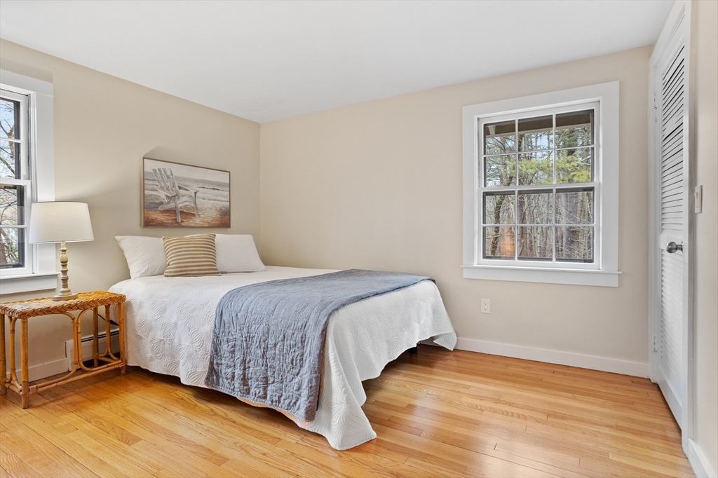 103 Newtown Road Acton, MA 01720 - Photo 24 of 42 a bedroom with a bed and wooden floor