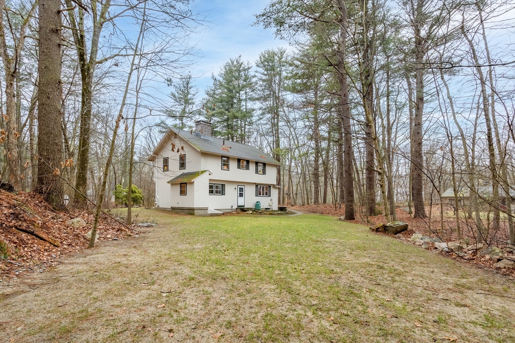 103 Newtown Road Acton, MA 01720 - Photo 33 of 42 a view of a house with a large tree and a yard