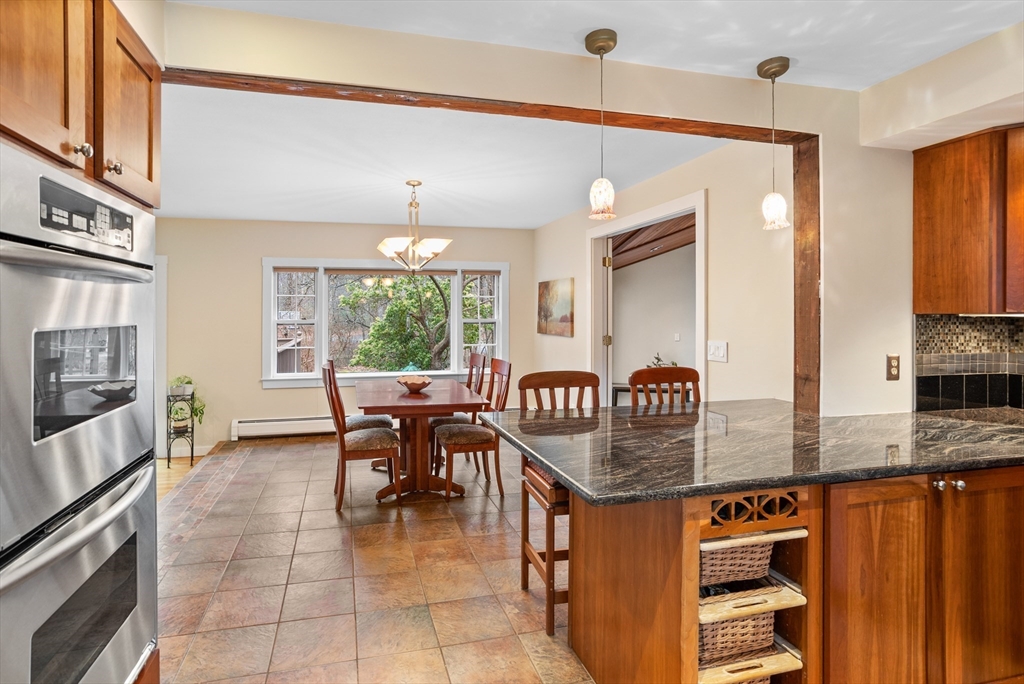 103 Newtown Road Acton, MA 01720 - Photo 7 of 42 a kitchen with granite countertop a stove a sink a dining table and chairs