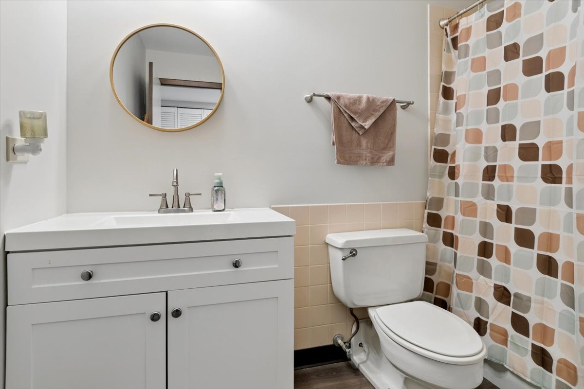 6545 Main Street, Unit 407 Downers Grove, IL 60516 - Photo 13 of 18 a bathroom with a toilet a sink and a mirror