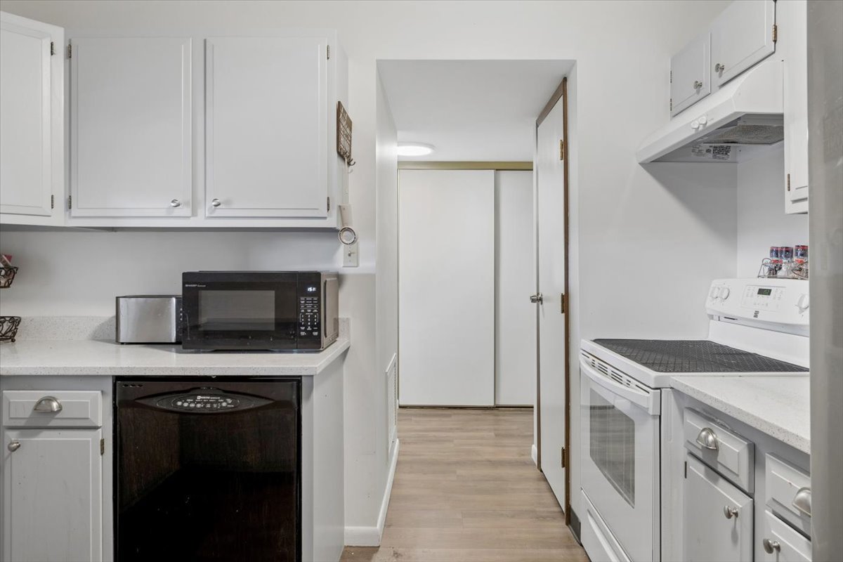 6545 Main Street, Unit 407 Downers Grove, IL 60516 - Photo 6 of 18 a kitchen with white cabinets and black appliances
