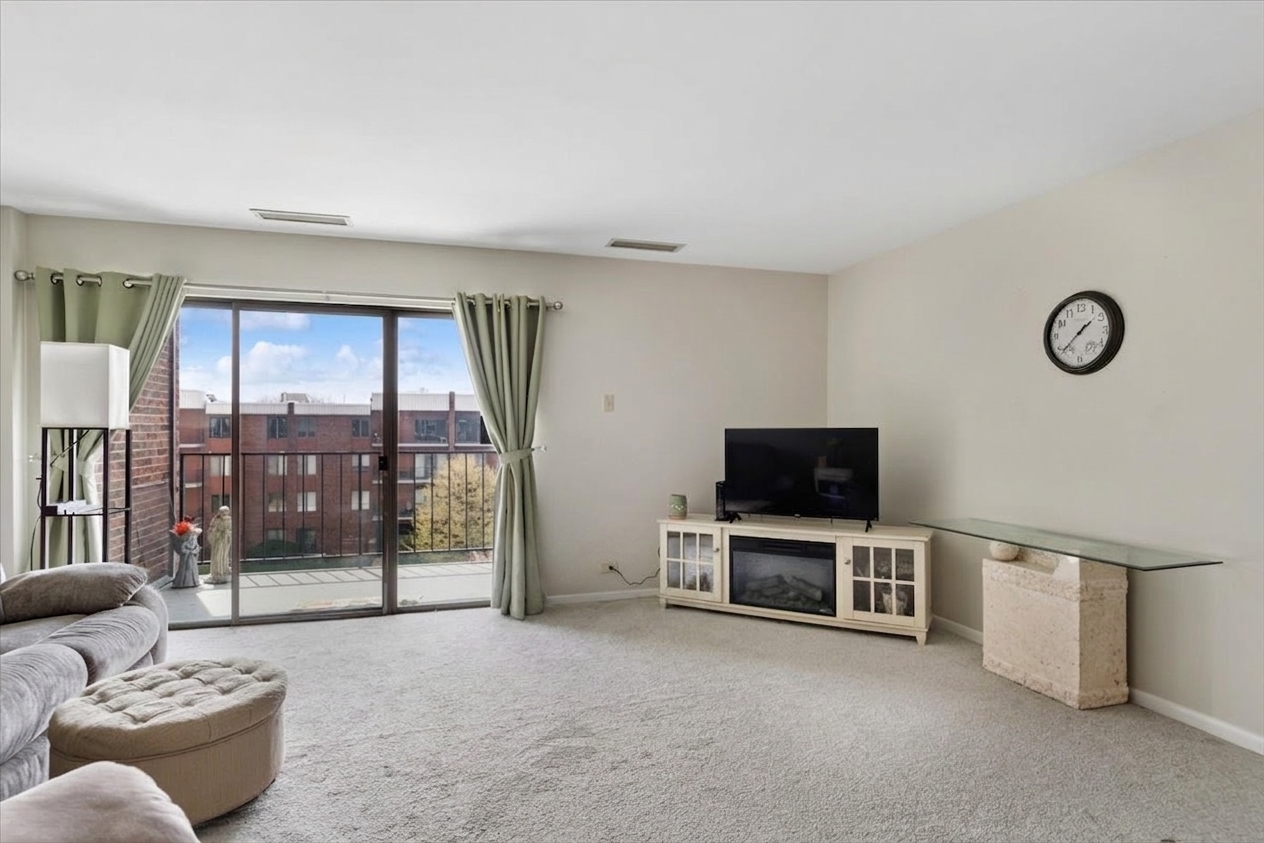 6545 Main Street, Unit 407 Downers Grove, IL 60516 - Photo 7 of 18 a living room with furniture and a flat screen tv