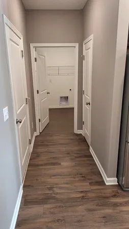 a view of a hallway with wooden floor and staircase