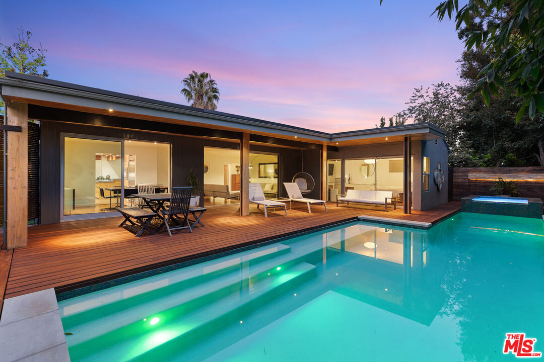 a view of a swimming pool with lawn chairs and a yard