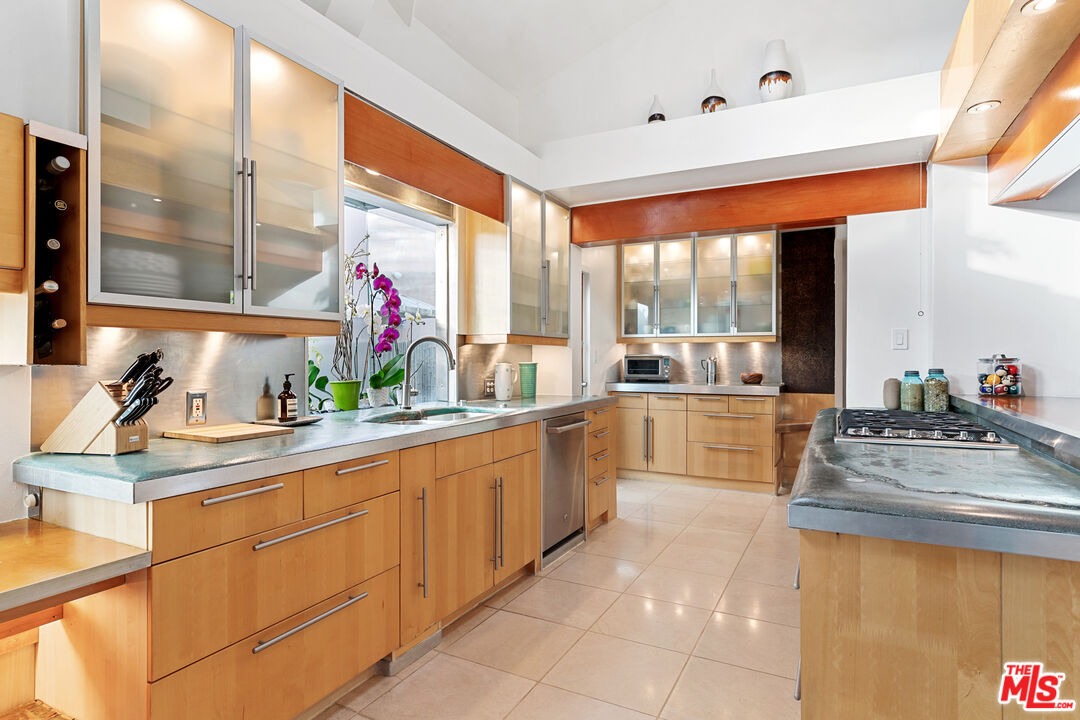 14840 Sunset Boulevard Pacific Palisades, CA 90272 - Photo 11 of 33 a large white kitchen with kitchen island a large window in it