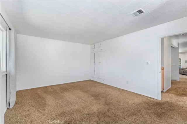 an empty room with windows and closet