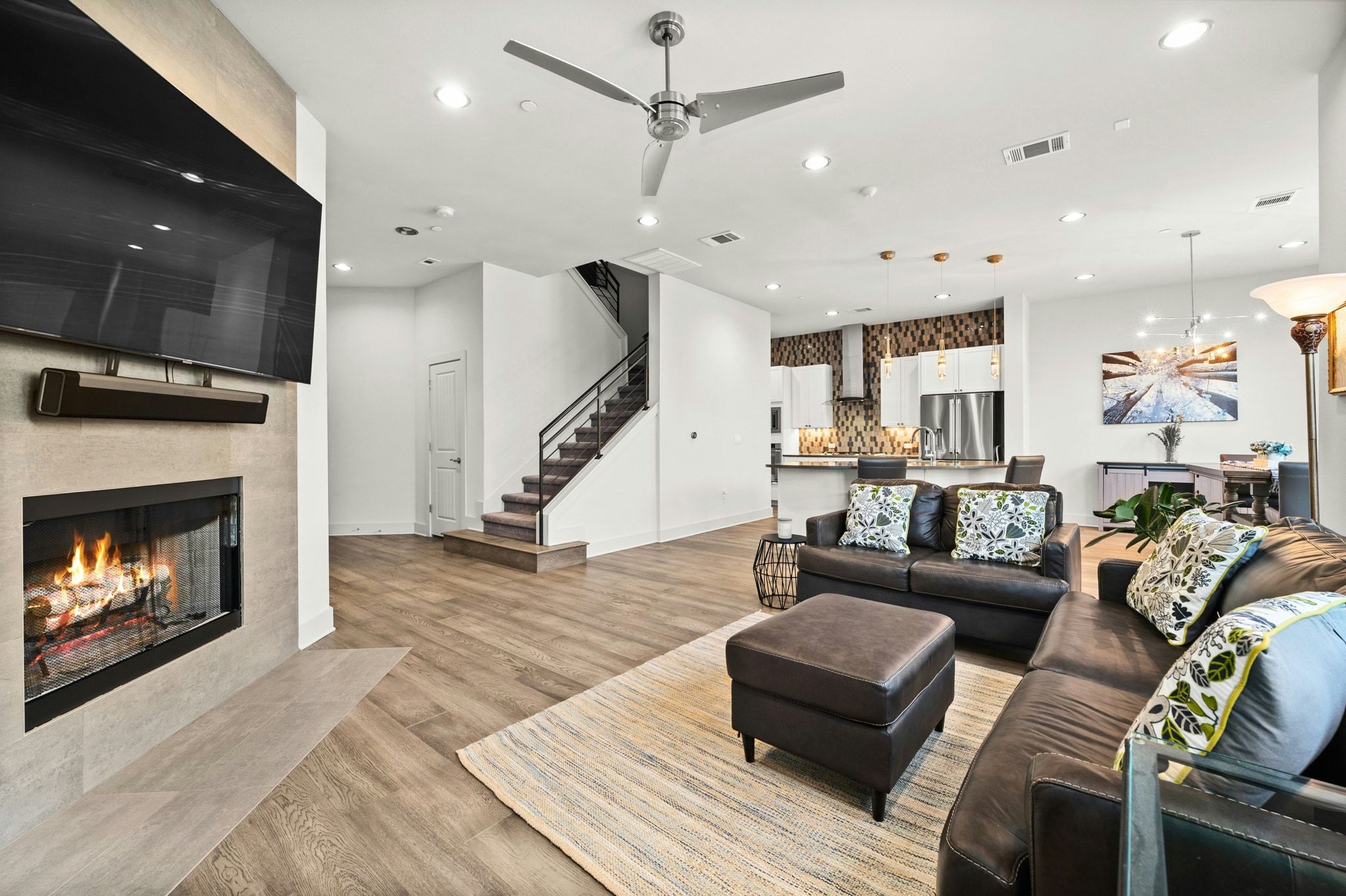 8110 Ranch Road 2222, Unit 92 Austin, TX 78730 - Photo 4 of 40 Open-concept living area with wood-finish flooring, a contemporary fireplace with tile surround, and a ceiling fan