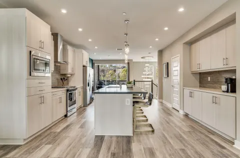a kitchen with white cabinets and stainless steel appliances
