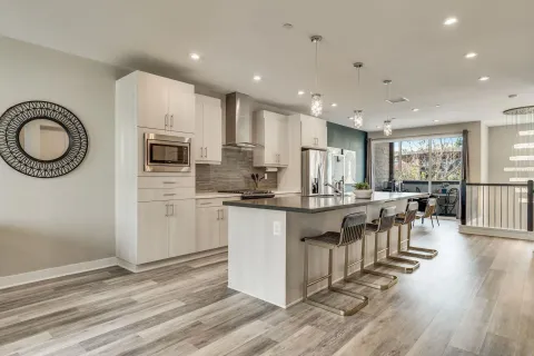 a kitchen with kitchen island granite countertop a sink cabinets and wooden floor