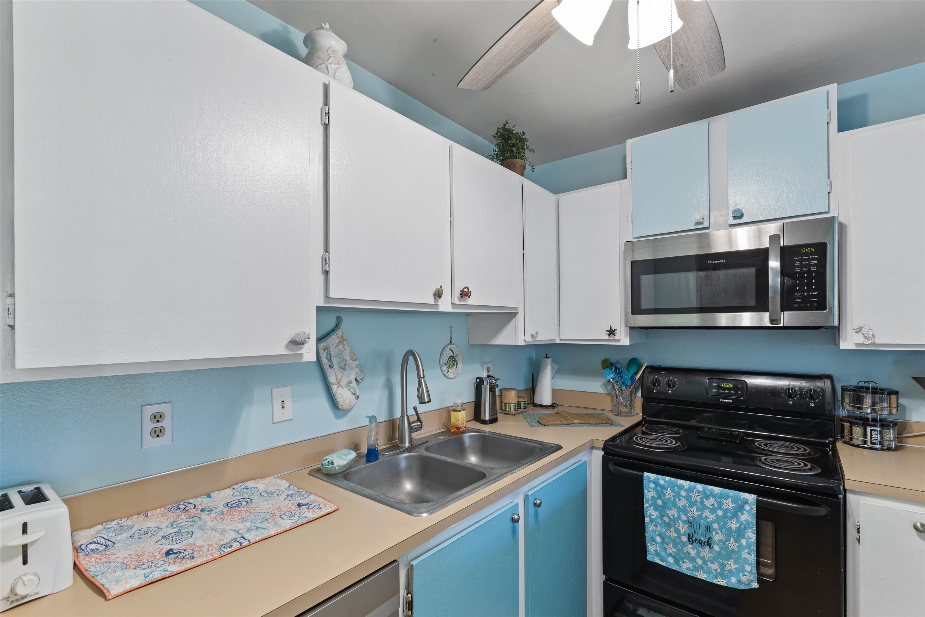 3740 Lower Honoapiilani Road, Unit F306 Lahaina, HI 96761 - Photo 12 of 30 a kitchen with granite countertop a stove a sink and a microwave