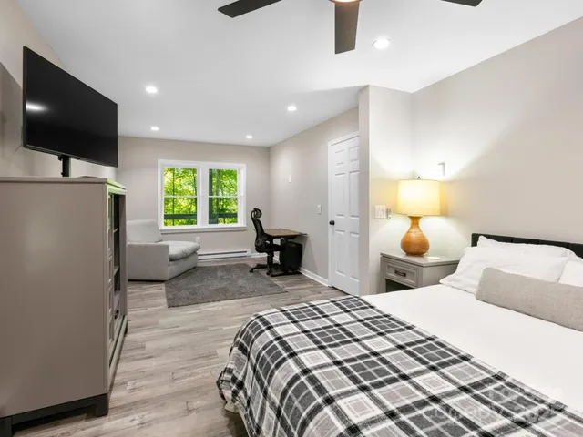 a bedroom with a large bed and a flat screen tv