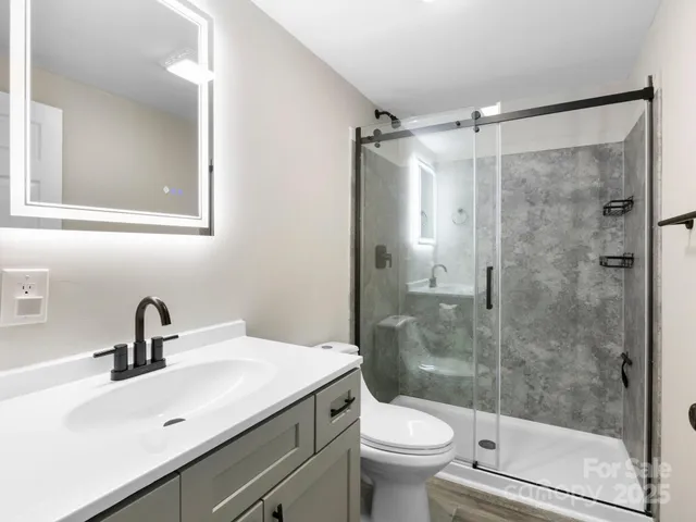 a bathroom with a sink mirror toilet and shower
