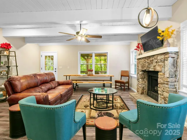 a living room with furniture a fireplace and a chandelier