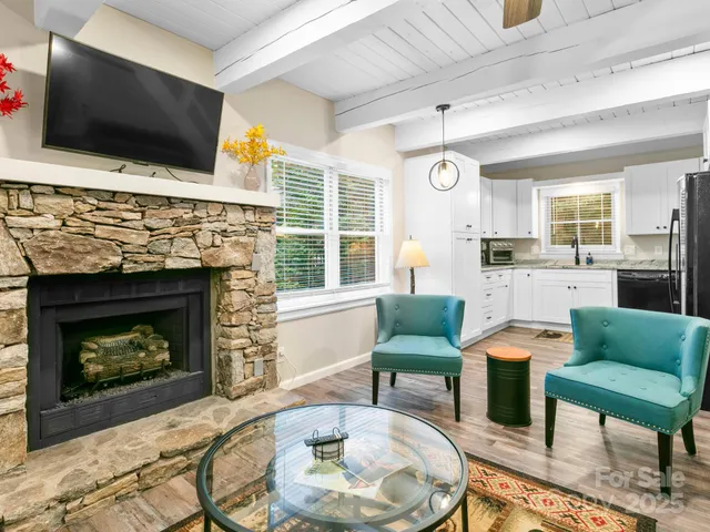 a living room with furniture a flat screen tv and a fireplace