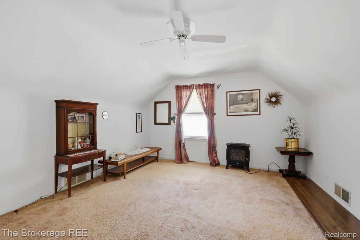 613 East Atherton Road Flint, MI 48507 - Photo 22 of 42 Sloped ceilings, window with natural light, ceiling fan, and mixed flooring with carpeting and wood-finish sections