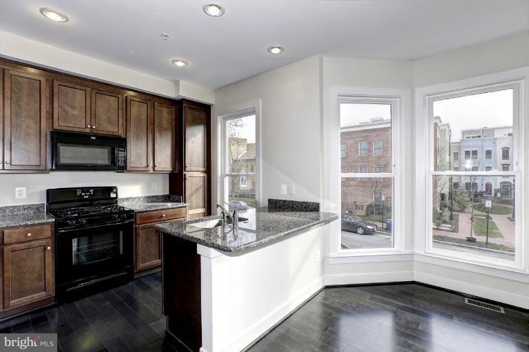 915 4th Street Southeast Washington, DC 20003 - Photo 8 of 24 a kitchen with stainless steel appliances granite countertop a stove a sink and a microwave