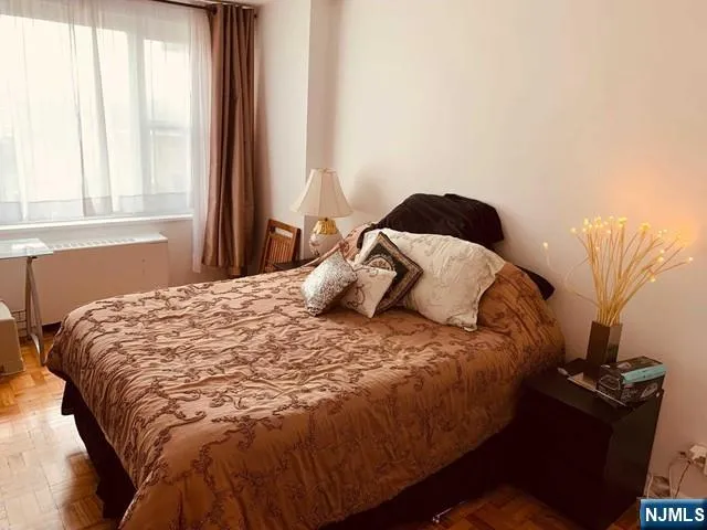 a large bed sitting in a bedroom next to a window