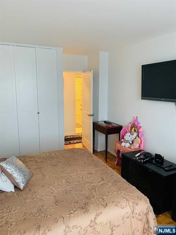 2000 Linwood Avenue, Unit 10M Fort Lee, NJ 07024 - Photo 12 of 28 a bedroom with a bed and a flat screen tv