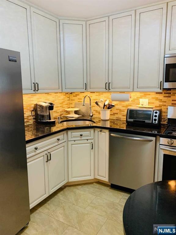 2000 Linwood Avenue, Unit 10M Fort Lee, NJ 07024 - Photo 7 of 28 a kitchen with stainless steel appliances granite countertop a sink a stove and a microwave