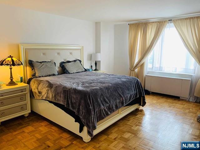 2000 Linwood Avenue, Unit 10M Fort Lee, NJ 07024 - Photo 8 of 28 a bed sitting in a bedroom next to a window