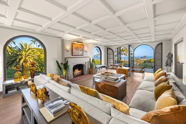 a living room with furniture a fireplace and a chandelier