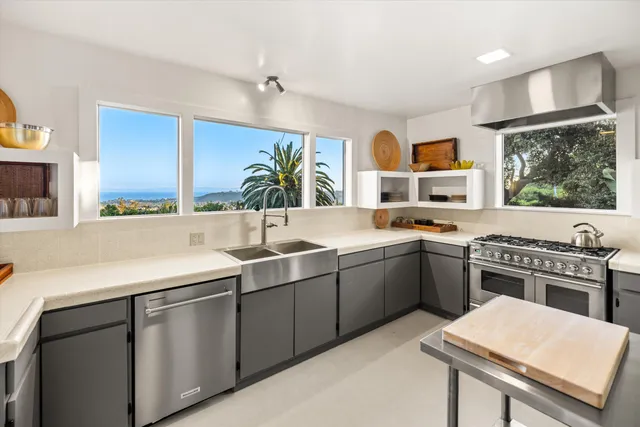 a kitchen with stainless steel appliances a sink counter space and a window