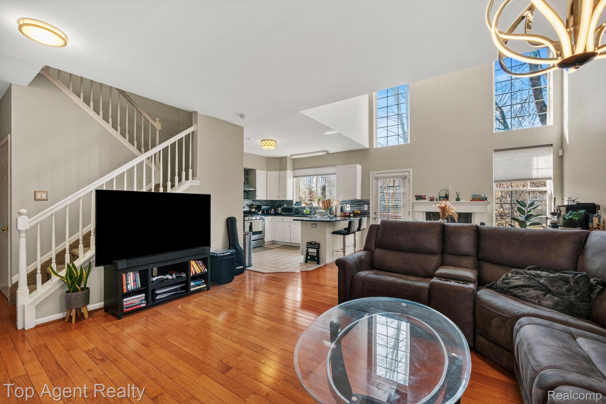 41567 Glade Road, Unit 20 Canton, MI 48187 - Photo 7 of 47 Living room with light wood-style floors, a high ceiling, and a chandelier