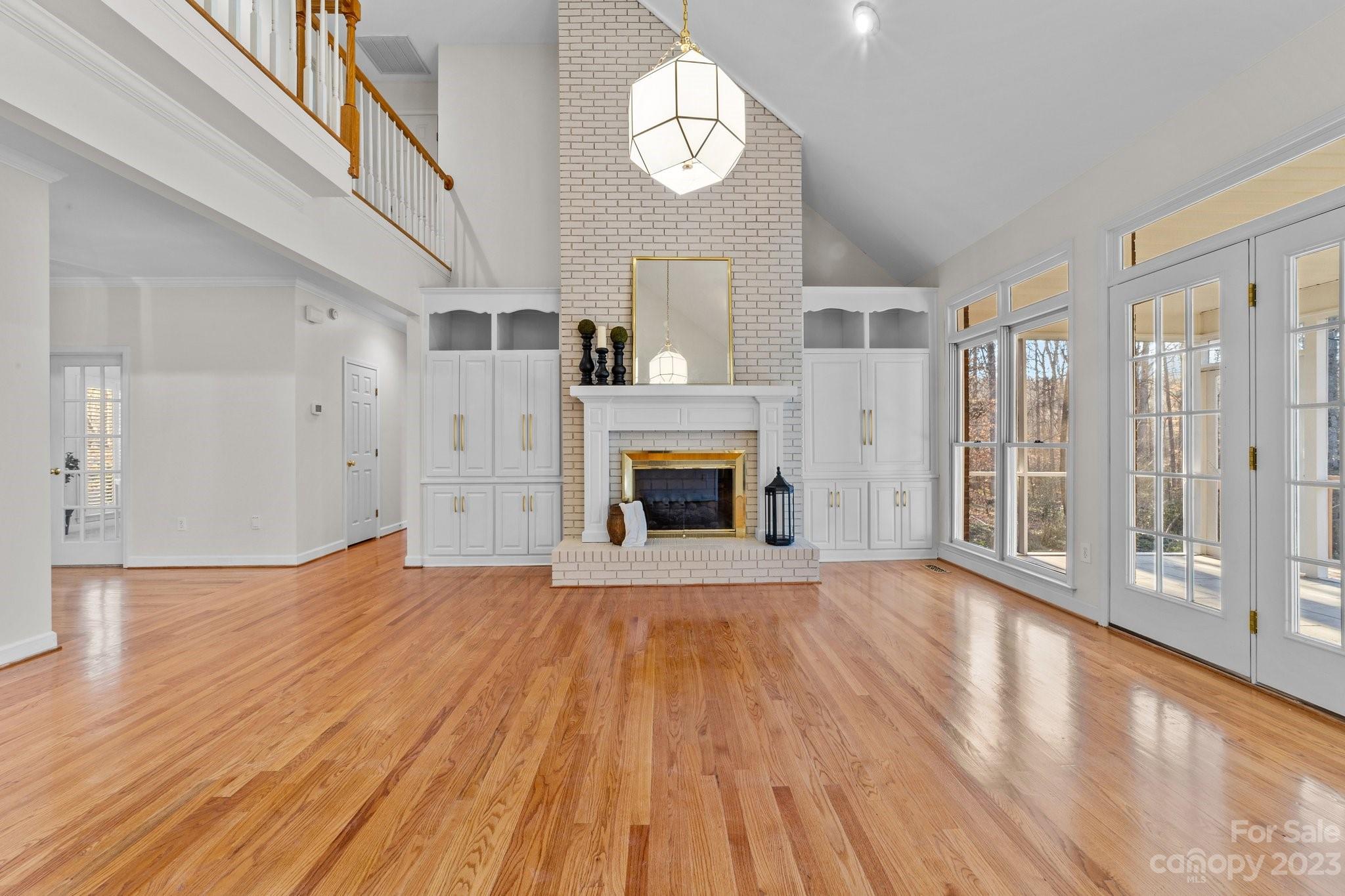 5476 Deer Run Court Davidson, NC 28036 - Photo 15 of 48 a view of an empty room with wooden floor fireplace and a window