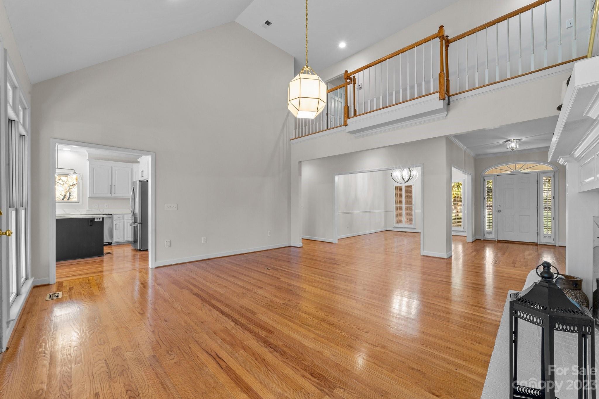 5476 Deer Run Court Davidson, NC 28036 - Photo 16 of 48 a view of a hallway with wooden floor windows and a kitchen